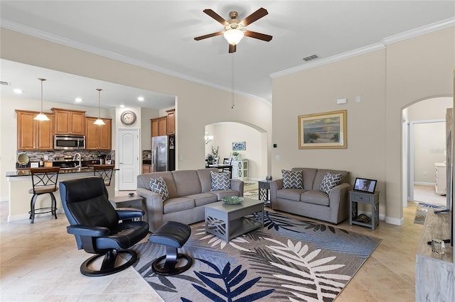 living room featuring baseboards, arched walkways, and crown molding