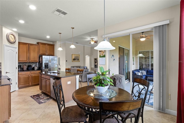 kitchen featuring dark countertops, visible vents, open floor plan, decorative backsplash, and appliances with stainless steel finishes