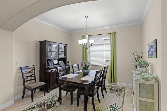 dining area featuring arched walkways, a chandelier, crown molding, and baseboards