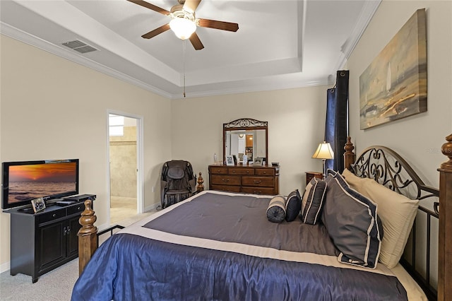 bedroom featuring visible vents, a tray ceiling, connected bathroom, crown molding, and light colored carpet