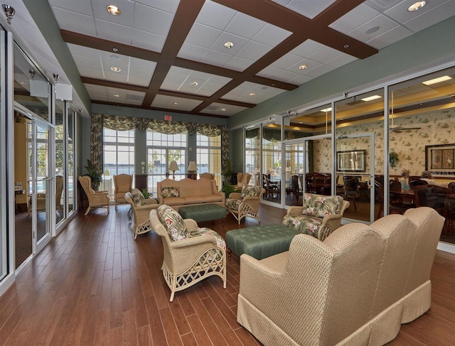 living room with wallpapered walls, plenty of natural light, wood finished floors, and coffered ceiling