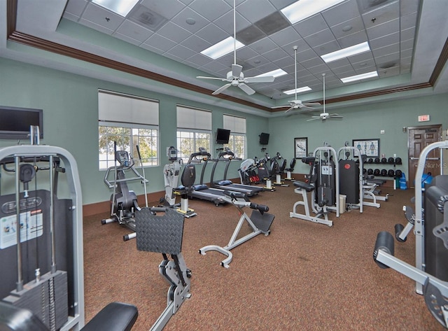workout area with a drop ceiling, ceiling fan, a raised ceiling, and visible vents
