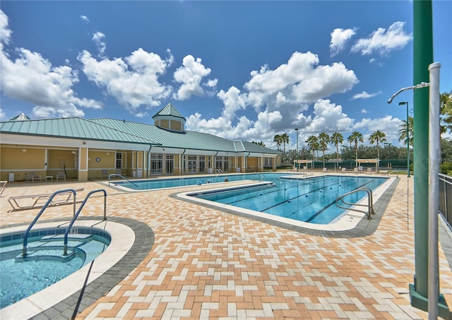 pool featuring a patio, fence, and a hot tub