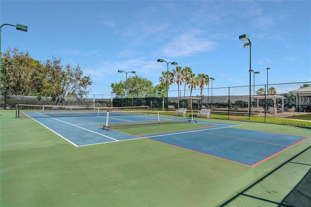 view of tennis court featuring fence