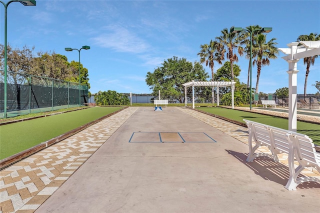 view of community featuring fence and a pergola