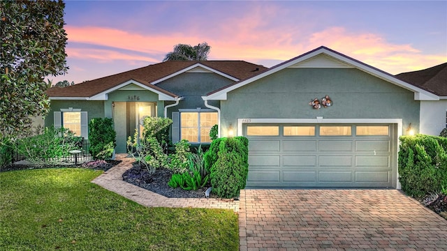 single story home with an attached garage, decorative driveway, and stucco siding