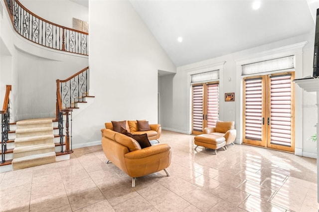 sitting room featuring stairs, high vaulted ceiling, french doors, and baseboards