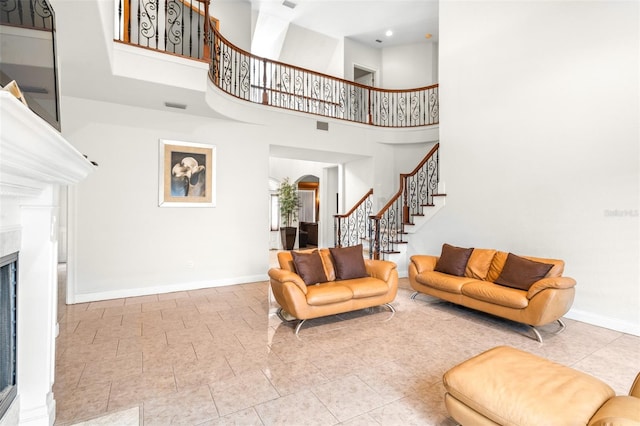 living room with stairs, visible vents, a high end fireplace, and baseboards