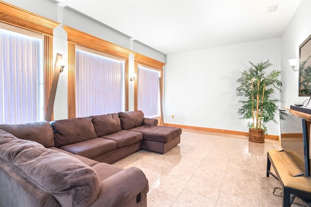 living room with light tile patterned floors, visible vents, and baseboards