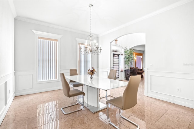 tiled dining area featuring arched walkways, a decorative wall, ornamental molding, and a notable chandelier