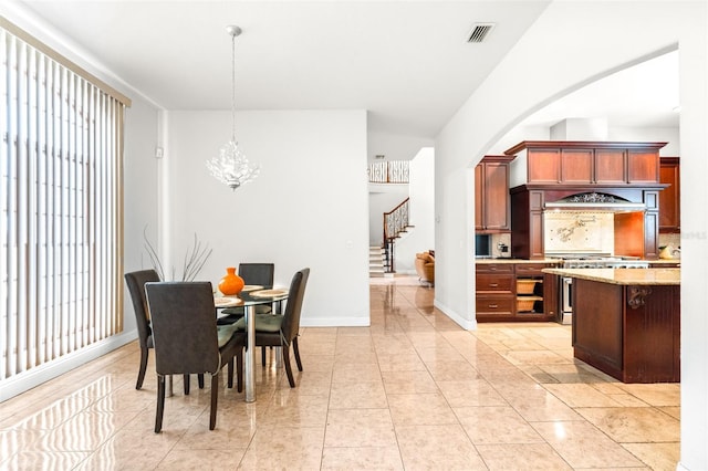 dining area featuring light tile patterned floors, visible vents, stairway, an inviting chandelier, and baseboards