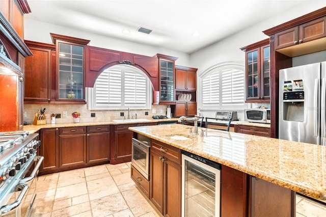 kitchen featuring tasteful backsplash, visible vents, wine cooler, stainless steel appliances, and a sink
