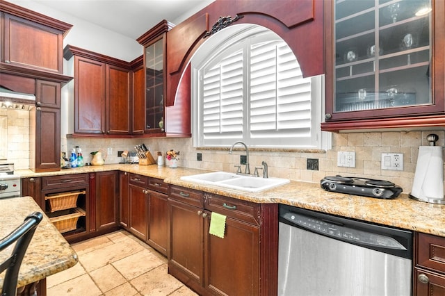 kitchen featuring dark brown cabinets, stainless steel dishwasher, a sink, and tasteful backsplash