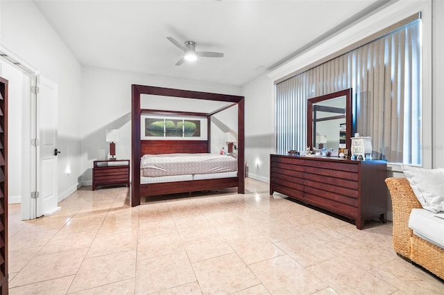 tiled bedroom with ceiling fan and baseboards