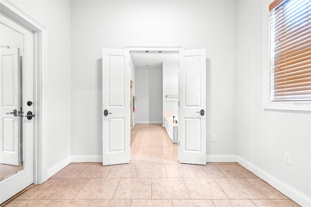 unfurnished room featuring light tile patterned floors and baseboards