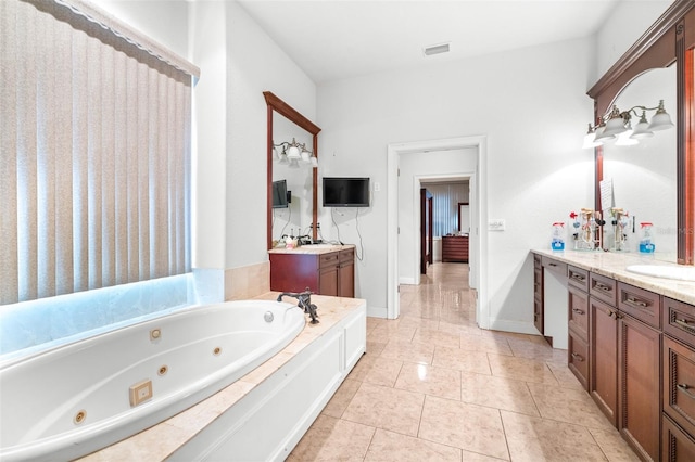 bathroom with visible vents, vanity, a whirlpool tub, baseboards, and tile patterned floors