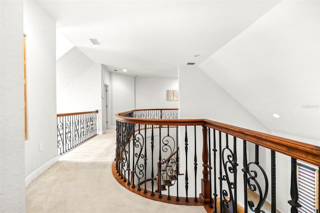 corridor featuring carpet flooring, vaulted ceiling, visible vents, and baseboards