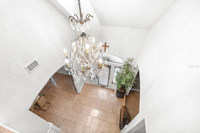 foyer entrance with visible vents, a chandelier, baseboards, and tile patterned floors
