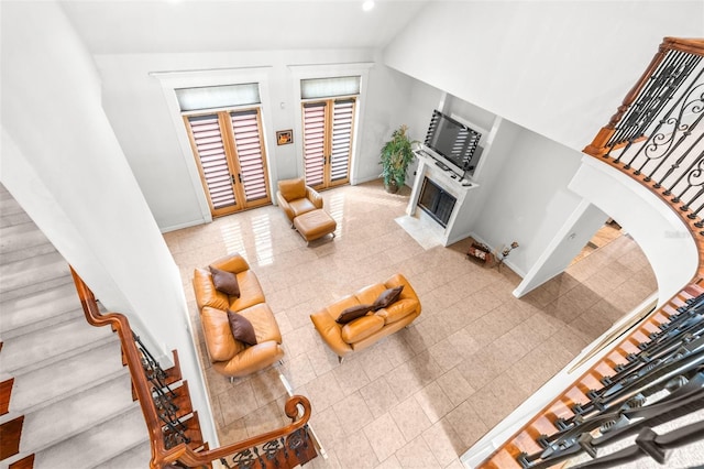 living room with stairs, a fireplace with flush hearth, and baseboards