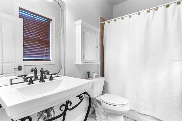 bathroom featuring a shower with curtain, a sink, and toilet