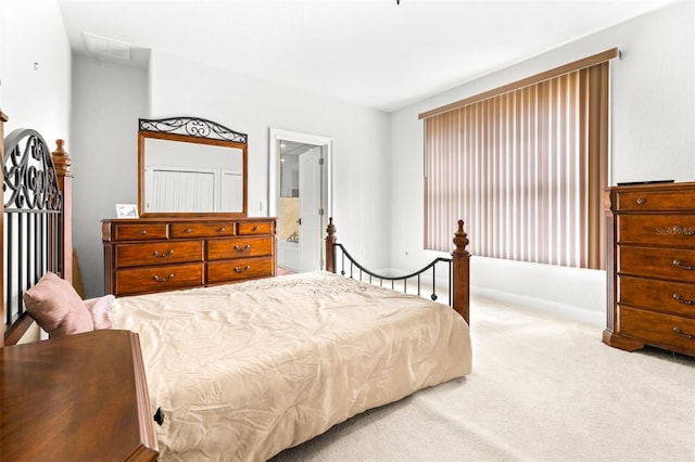 bedroom featuring visible vents, carpet flooring, and ensuite bathroom