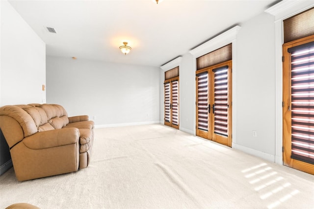 living area with carpet, visible vents, and baseboards