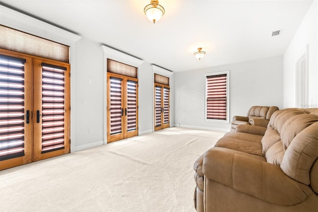 living area with french doors, carpet flooring, visible vents, and baseboards