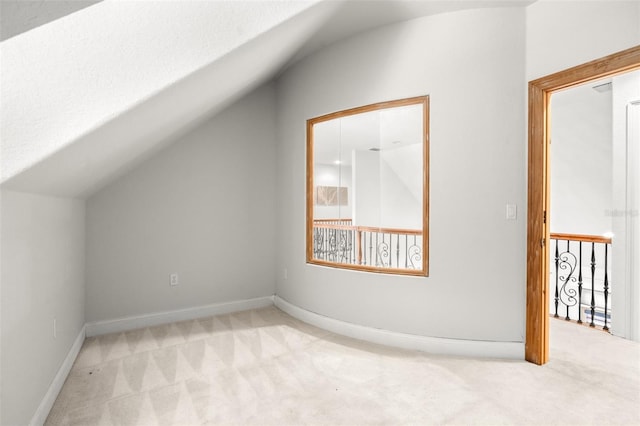bonus room featuring lofted ceiling, carpet flooring, and baseboards