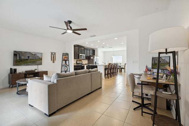 living room with light tile patterned floors, visible vents, a ceiling fan, and recessed lighting