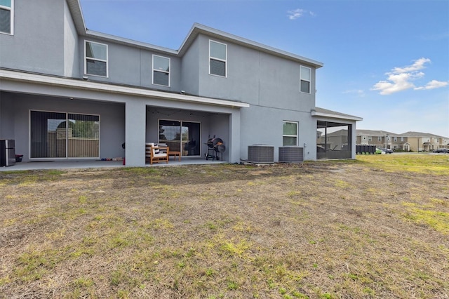 back of property with central AC unit, a patio area, and stucco siding