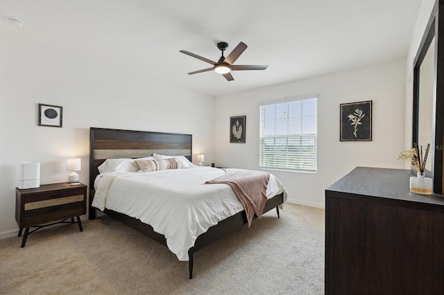 bedroom with ceiling fan, baseboards, and light colored carpet