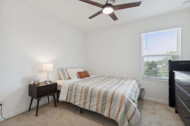 bedroom featuring ceiling fan, baseboards, and light colored carpet