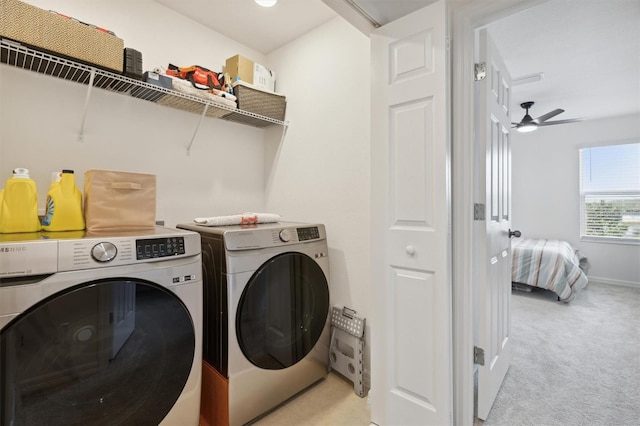 clothes washing area with light colored carpet, ceiling fan, washer and dryer, laundry area, and baseboards