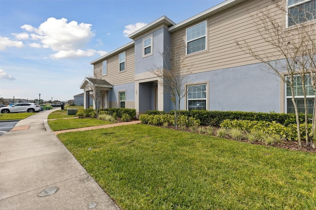 multi unit property with a front yard, central AC unit, and stucco siding