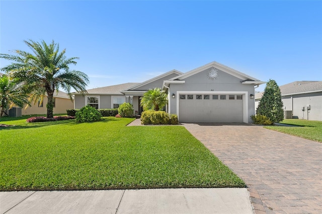 ranch-style house featuring a garage, a front lawn, decorative driveway, and stucco siding