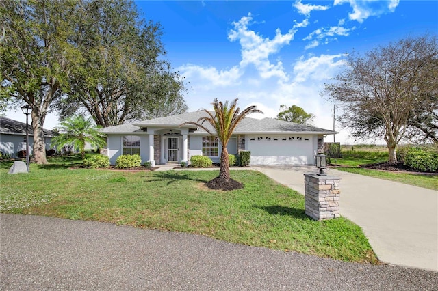 ranch-style house featuring a garage, concrete driveway, and a front lawn