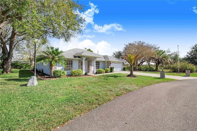 ranch-style home with a front yard, driveway, and an attached garage