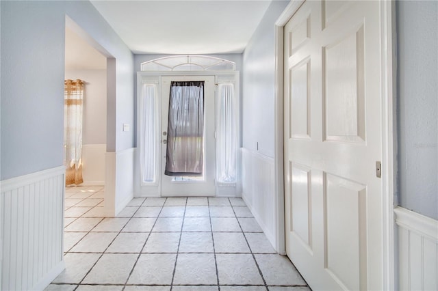 entrance foyer featuring a wainscoted wall and light tile patterned floors