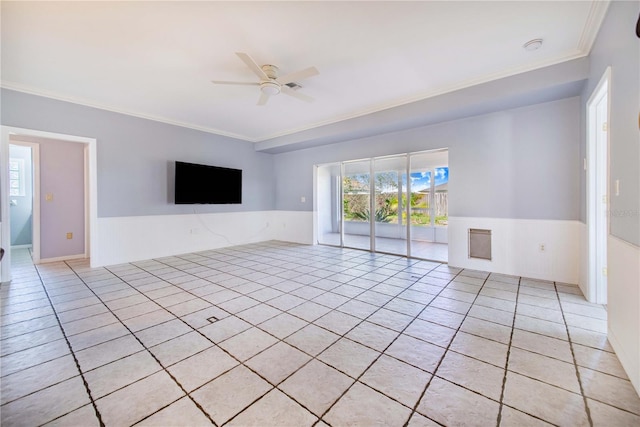 unfurnished room with a ceiling fan, a wainscoted wall, light tile patterned flooring, and crown molding