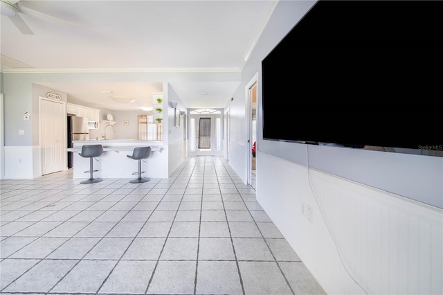 hallway featuring ornamental molding and light tile patterned floors