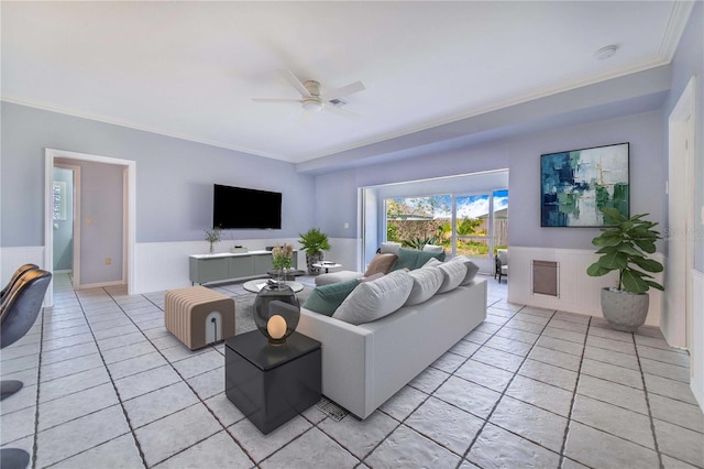 living room featuring ornamental molding, light tile patterned flooring, and ceiling fan