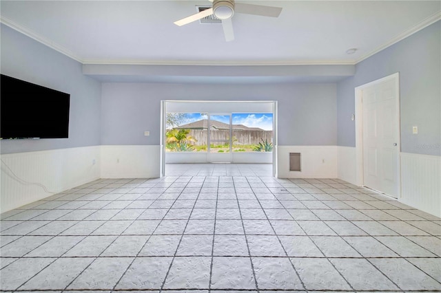 spare room featuring ornamental molding, wainscoting, and light tile patterned floors