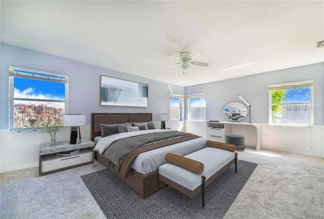 bedroom featuring ceiling fan, multiple windows, baseboards, and carpet flooring