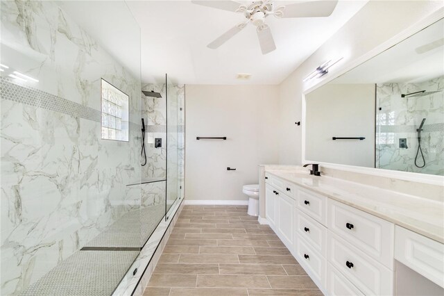 bathroom with a marble finish shower, baseboards, toilet, vanity, and wood finish floors