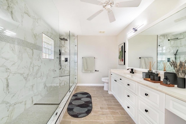 full bath featuring toilet, baseboards, a marble finish shower, wood tiled floor, and double vanity