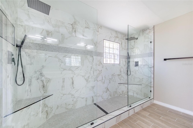 full bath featuring baseboards, a marble finish shower, and wood tiled floor