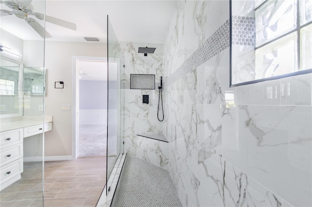 bathroom featuring visible vents, ceiling fan, vanity, and a marble finish shower