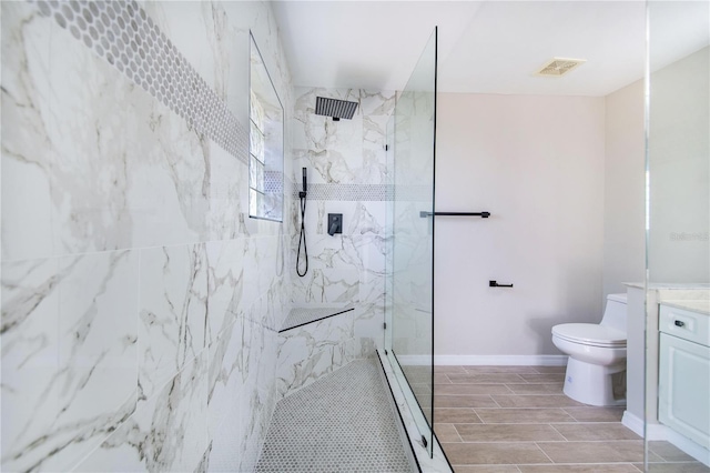 bathroom with a marble finish shower, baseboards, visible vents, toilet, and wood tiled floor