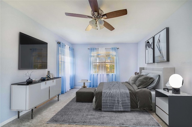 bedroom with light carpet, baseboards, and a ceiling fan