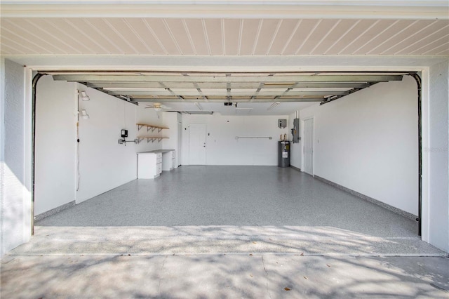 garage featuring water heater, electric panel, and a garage door opener